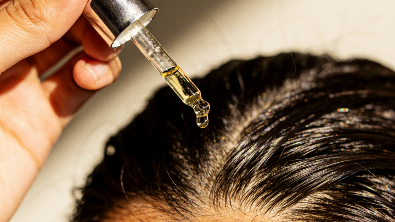 Hair Growth Oil being applied to hair by dropper