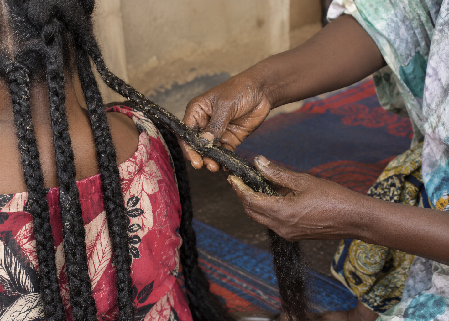 Chebe treatment being applied along long plaited hair
